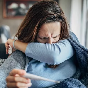 woman coughing in her sleeve