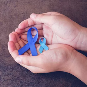 Hands holding two cancer ribbons