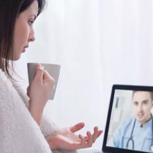 Woman talking to physician on PC. 