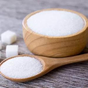 sugar in wooden spoon and wooden bowl