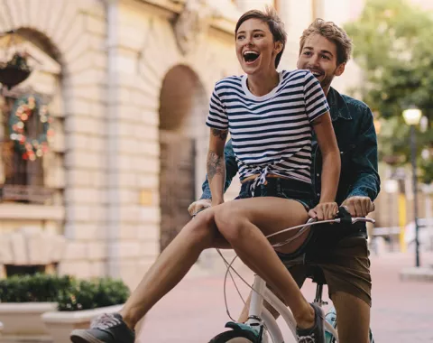 Young couple riding a bike outside