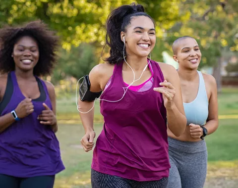 Smiling young women jogging outside