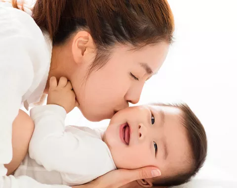 Mom kissing infant baby